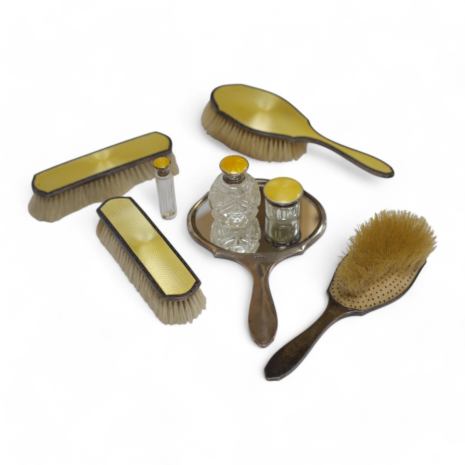 A George V silver and yellow guilloche five piece enamel dressing table set, by Henry Matthews, Birmingham, 1922/1923, mirror 23.2cm and three similar toilet jars. Condition - poor to fair